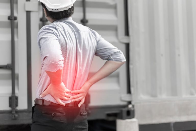 Engineer with back pain on construction site background,Highligh