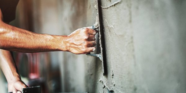 Closeup,Hand,Of,Worker,Plastering,Cement,At,Wall,For,Building putzarbeiten-bau-exoskelette